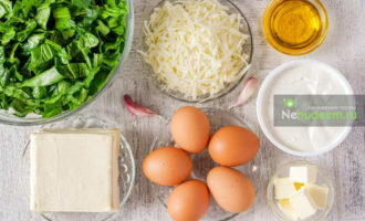 Подготовить продукты: тесто вынуть из упаковки и выложить на припыленный мукой стол, чтобы оно разморозилось. Шпинат и черемшу хорошо промыть и порезать. Сыр натереть на крупной тёрке. Отварить вкрутую 5 яиц (6-ое яйцо потребуется для начинки сырым).