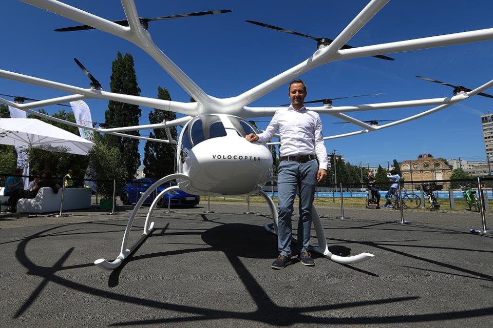 Флориан Рейтер, исполнительный директор Volocopter GmbH, с многокороторным электрическим вертолетом Volocopter 2X.