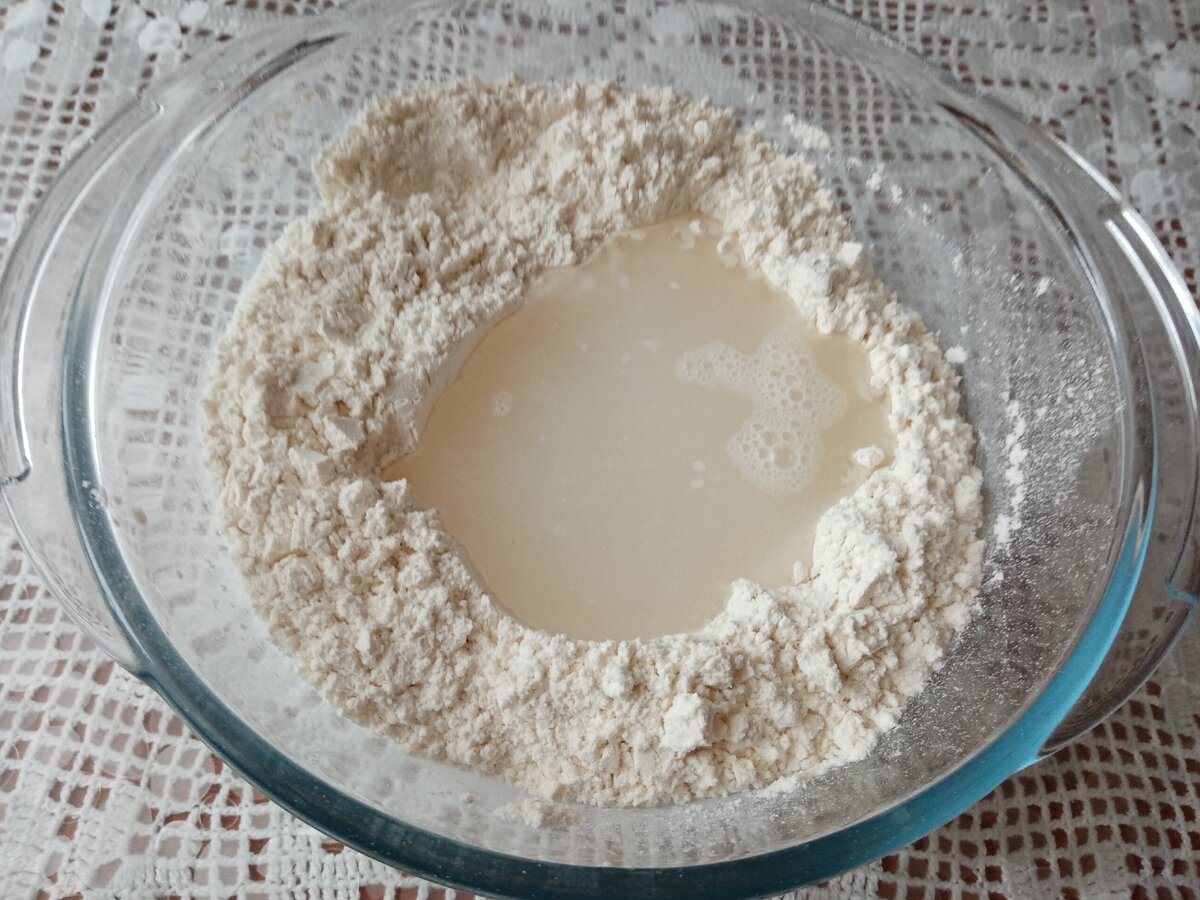 Сделать в муке лунку и влить тёплую воду.