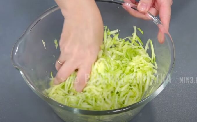 1.  Кабачки натираю на крупной терке. Солю, перемешиваю, оставляю на 10 минут. Нарезаю зеленый лук и зелень петрушки. Адыгейский сыр разминаю вилкой. Кабачки отжимаю и сливаю лишний сок.