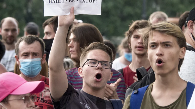 Мужчина держит плакат с надписью "Наш Край, наш губернатор!"во время несанкционированной акции протеста в Хабаровске.