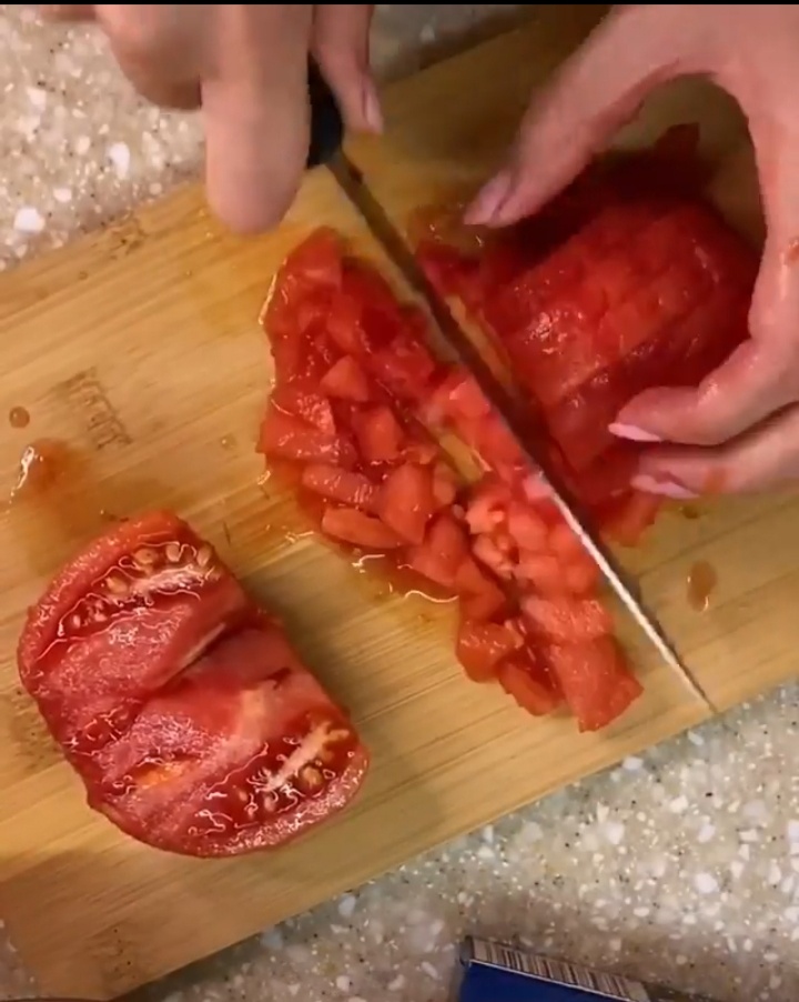 Надрезаем помидорки и обдаем их кипятком,что бы легче было снять с них шкурку. Нарезаем на небольшие купики.Так же нарезаем болгарский перчик,лук и чеснок(чеснок нарезаем очень мелко или воспользуйтесь чеснокодавилкой).