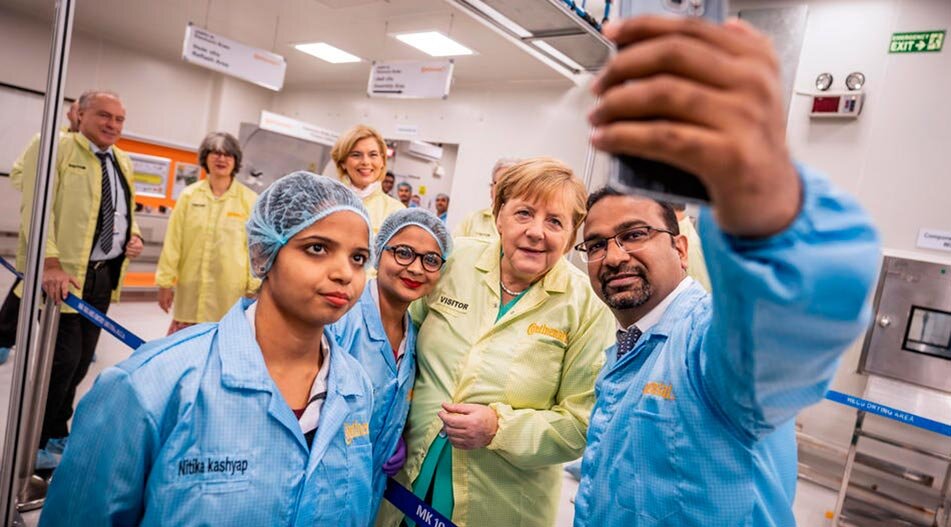 Канцлер Германии Ангела Меркель (M, CDU) делает селфи с сотрудниками, посещающими Continental Automotive Components India. Фото: dpa / Michael Kappeler