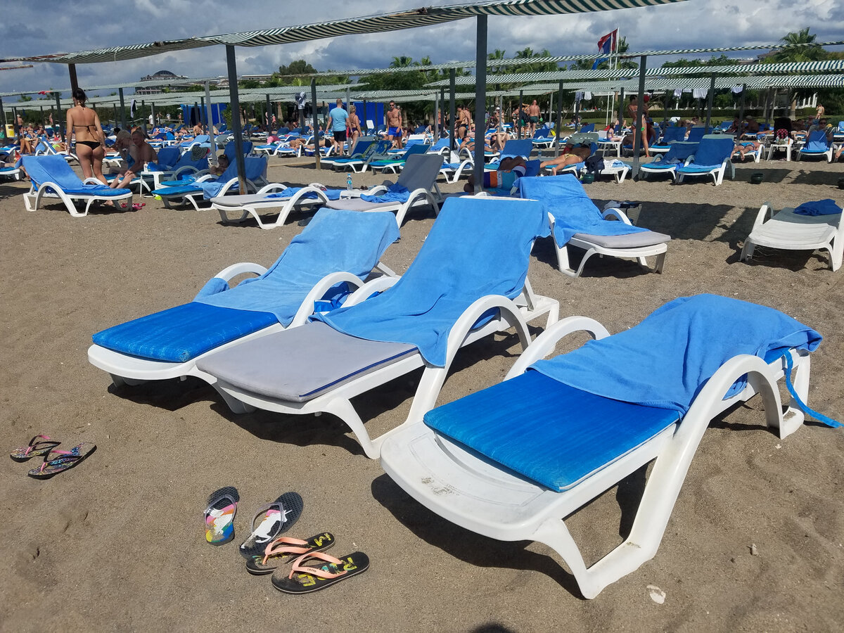 Пляжная атмосфера. Чистый песочек, много шезлонгов.