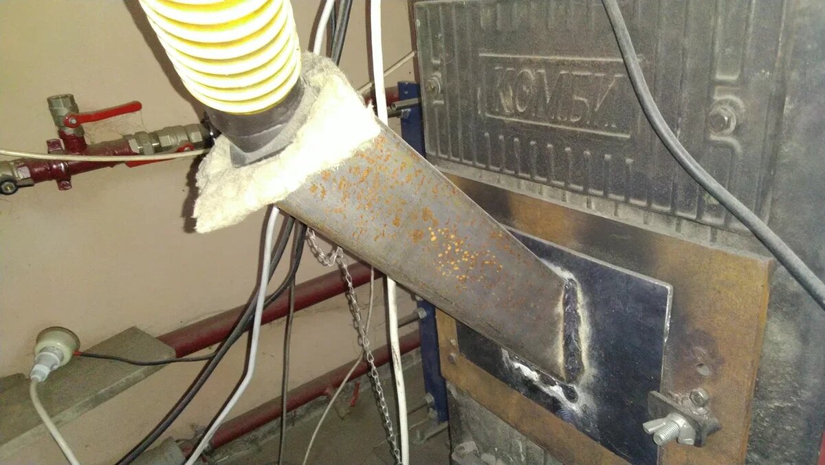 Самодельный фланец и труба, через которую пеллеты попадают в топку котла. Угол установки трубы максимальный, чтобы пеллетная труха, которой очень много в мешках с пеллетами, проскакивала в топку. 