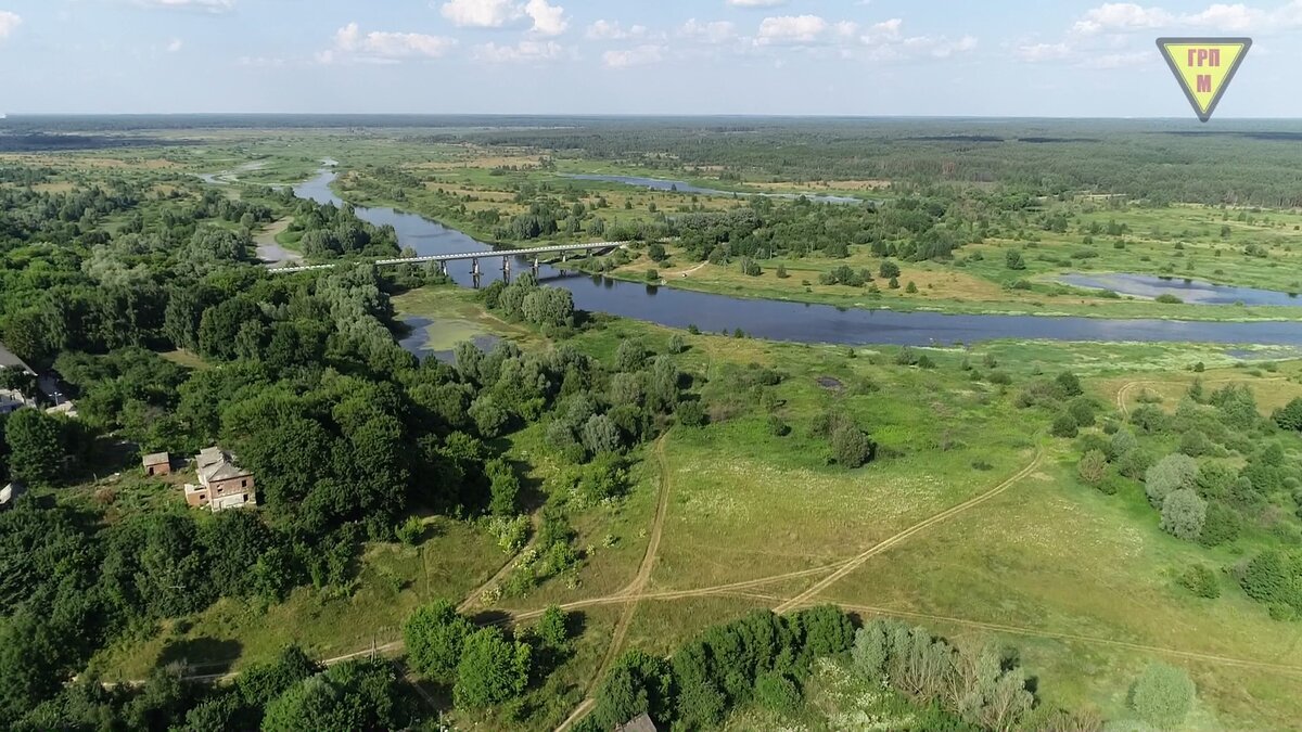 Река Ипуть, мост через неё и первые дома села Ущепрье на возвышенности.