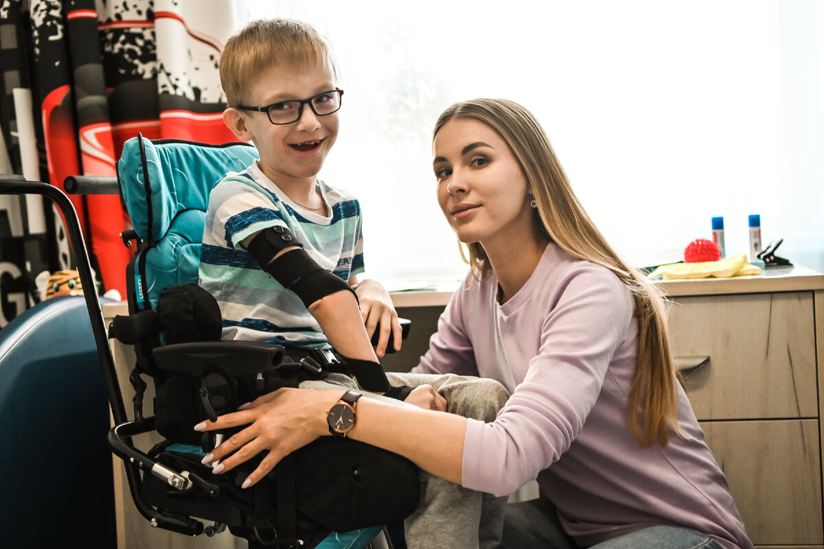 Наталия Глухих с учеником фонда "Я особенный". У Вовы ДЦП и слабое зрение. Он плохо проговаривает слова, но родные все равно называют его "мальчик-радио". Он открыт миру и любит болтать так,как умеет.