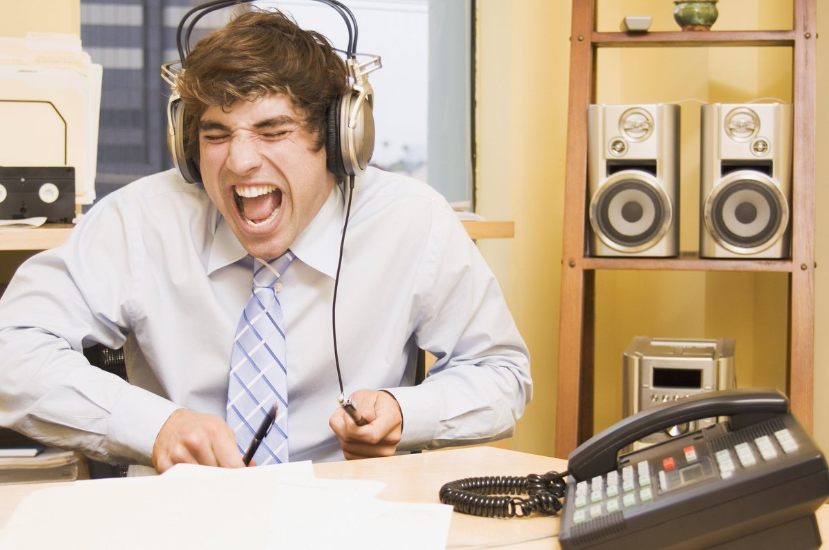 Музыка которая играет на радио. Человек в наушниках. Человек слушает музыку. Человек слушает музыку на работе. В наушниках в офисе.