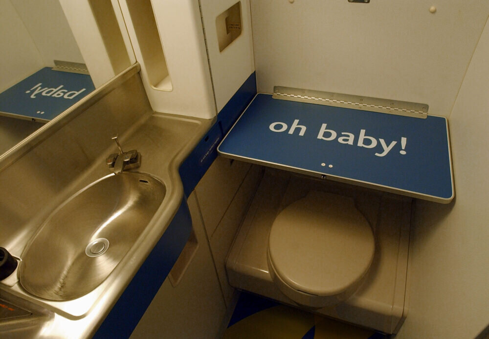 Бывает туалет. Туалет в самолете. Педенальгфй столик в самолете. Пеленальный столик в самолете. Петкнальныц столик в туалете самолета.