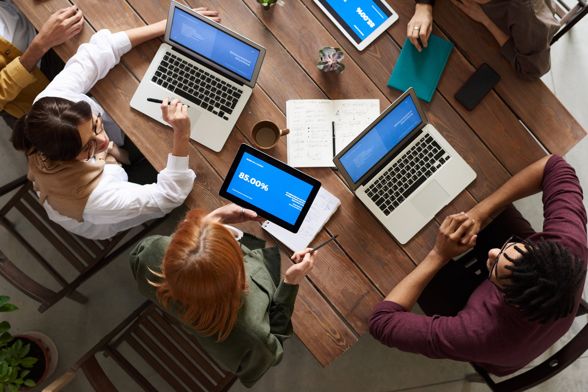 pexels.com/photo/top-view-photo-of-group-of-people-using-macbook-while-discussing-3182773/