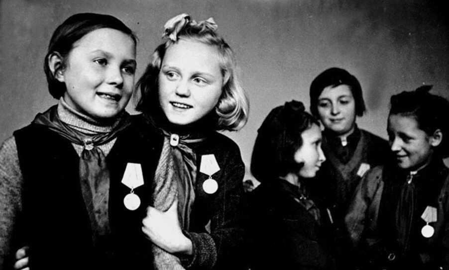 Ученицы 4-го класса 47-й школы г. Ленинграда, награжденные медалями «За оборону Ленинграда». На фото слева направо: Житкова, Г. Петрова, Авдеева, М. Гнеленко, Романил. Автор: Георгий Коновалов. 27.09.1943. Источник: leningradpobeda.ru