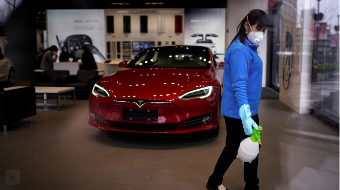 Рабочий дезинфицирует салон Tesla в Шанхае. Тесла ведет общий рынок электромобилей в Китае все выше, поскольку она снижает цены и расширяет местное производство. © Reuters