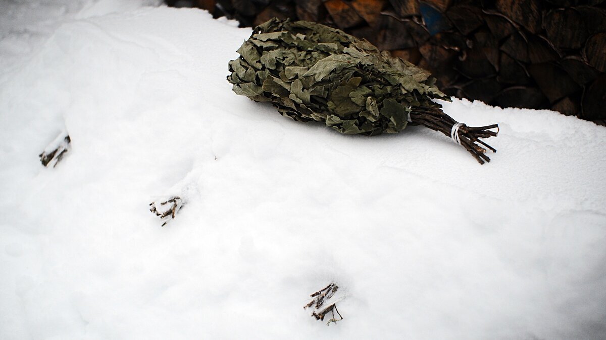 Закопанные в снег банные веники - только ручки торчат