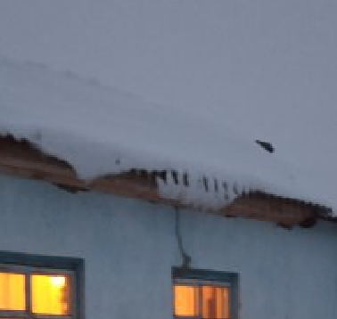 Снег начал сходить по шиферу крыши и завис, прихваченный морозом