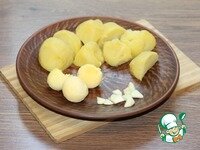     2. Картофель отварить в мундире, охладить и очистить, нарезать дольками. Чеснок порубить. Яйца очистить, желток отделить.
