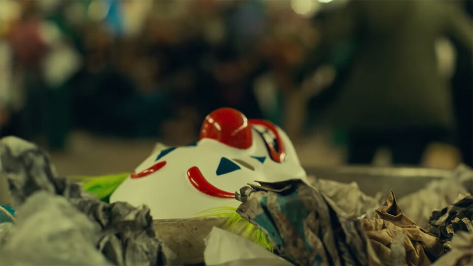 Автор «Мальчишника в Вегасе» Тодд Филлипс снял настоящую скорсезевскую драму об изгое, доведенном обществом до отчаяния. И, возможно, переплюнул Кристофера Нолана в подходе «more dark, more realistic», считает Ольга Белик.Готэм начала 1980-х раздирает социальный кризис. Безработица, общество озлоблено. Местный богач Томас Уэйн, баллотируясь в мэры, необдуманно назвал горожан клоунами и породил волну протестов: люди собираются перед мэрией в масках и с плакатами «Мы не клоуны», требуя уважения и лучшей жизни. К тому же город наводнили полчища крыс. Суперкрыс, как их прозвали в прессе. Вот в такой обстановке живет Артур Флек (Хоакин Феникс), которому мама (Фрэнсис Конрой) с детства говорила, что он рожден нести людям радость и веселье, и учила всегда улыбаться.

Артур работает клоуном-аниматором и пытается стать стендап-комиком, но нести веселье в массы получается плохо. С начала и практически до конца фильма Артура постоянно оскорбляют, унижают и бьют, потому что он немножечко не в себе и страдает от приступов неконтролируемого смеха, которые наступают в самые неподходящие и трагические моменты, что провоцирует благовоспитанных горожан еще больше. Мама, за которой Артур трогательно ухаживает, ждет его в обшарпанной квартирке, и вместе они бесконечно смотрят ток-шоу телезвезды Мюррея Франклина (Роберт Де Ниро), попасть на которое Артур страстно мечтает. Такой вот, в общем, милый и безобидный человек, который нуждается в обычном тепле и возможности делать любимую работу. Но раз за разом получая по ребрам, Флек все меньше хочет улыбаться и быть милым. Окончательно его психика рушится, когда он совершает один страшный поступок, а позже узнает всю правду о себе и своем происхождении.
Тодд Филлипс, снявший трилогию «Мальчишник в Вегасе» и работавший над сценарием «Бората», как никто другой, знает обратную сторону смеха. Комики, мы помним, в жизни самый серьезный, одинокий и грустный народ (вспомните того же Джима Керри). Поэтому неудивительно, что он так мастерски рассказывает о переходе Артура Флека на темную сторону и разворачивает перед нами глубочайшую трагедию одинокого человека, отвергаемого обществом, потому что он «не такой». «Джокер» сделан максимально реалистично, без единого намека на хоть какую-то супергероику. Филлипс (он же и написал сценарий) взял культового персонажа, а затем, набрав понемножку фактуры из разных комиксов о Джокере, полностью выдумал его биографию, жизненные обстоятельства и дал ему новое имя. Все это для того, чтобы показать, как любой из нас может стать Джокером, а привычная американская мечта — на самом деле система унижения и насилия богатых над бедными.

Филлипс на пресс-конференции напомнил, что создателей оригинального Джокера вдохновил старый фильм «Человек, который смеется». Сам режиссер об этом не думал, для него вдохновением были фильмы 1970-х, включая, конечно, скорсезевских «Таксиста», «Бешеного быка» и «Короля комедии» — фильмы о надломленных одиночках, слетевших с катушек. В новом Джокере легко можно углядеть Трэвиса Бикла (есть даже парочка интерпретаций культовых сцен «Таксиста»), но в целом Филлипс больше хотел передать бунтарскую стилистику тех картин и дух того Нью-Йорка — прообраза Готэма. На это работают и стилизованные под старые фильмы титры, и цветовая гамма. «Джокер» будто бы снят на пленку и начинается в ярких красно-желто-синих тонах, которые по мере погружения героя в бездну безумия становятся все мрачнее и мрачнее, с грязным оттенком. Лишь в редкие минуты счастья Артура теплота и яркость красок возвращается.
Работает на атмосферу и музыка Хильдур Гуднадоттир, написавшей саундтрек к прогремевшему сериалу «Чернобыль». Мрачная, тревожная (струнные, ударные и в финале уже духовые), она очень точно отражает изменение состояние Артура — от подавленности до абсолютного отчаяния и, наконец, освобождения. Именно с помощью музыки показана и трансформация Артура в Джокера. Музыка — то, что персонаж постоянно слышит внутри себя и оттого постоянно танцует (Феникс превращает это в невероятный пластический перформанс). Филлипс говорит, что поступил необычно для создания саундтрека: отправил Гуднадоттир сценарий сразу же целиком, отчего композитор была счастлива, так как понимала весь лейтмотив. Фокус в том, что сценарий постоянно менялся на площадке («Мы в комедии всегда так делаем, поэтому я не понимал, почему меня спрашивают, как мне это удается», — смеется Филлипс), и некоторые композиции, написанные под исчезнувшие уже сцены, Филлипс и Феникс затем использовали для импровизаций и создания новых сцен в картине.

Хоакин Феникс в «Джокере» проделал традиционно колоссальную работу. Во-первых, изрядно похудел для роли («Это, знаете ли, начинает влиять и на твое психологическое состояние!»). Во-вторых, прочитал множество книг про убийц политиков и решил сделать своего героя таким, чтобы ни один психолог не смог поставить ему диагноз и вообще как-то определить его личность. В-третьих, отказался искать мотивацию персонажа. Каждый день они с Филлипсом открывали какую-то новую грань Артура Флека. В результате герой получился максимально сложным и непредсказуемым — уязвимым и яростным, сломленным и решительным, слабым и жестоким одновременно. «Мне было интересно показать в нем свет, попытки найти любовь, человеческое тепло и счастье, — говорит актер. — Я не думал о нем как о травмированном персонаже и не хотел давать ему какое-то одно определение».
Ну и, конечно, пресловутый смех Джокера. Филлипс придумал гениальное решение, заставив героя истерически смеяться в моменты, когда больше всего хочется рыдать. Своего рода суперслабость, которая позже становится одной из суперсил персонажа. Режиссер показал Фениксу кассету с пациентами, страдающими неконтролируемым смехом, и актер подумал, что не справится с задачей. «Я начал практиковаться один и через месяц попросил Тодда устроить мне прослушивание смеха. Мне было ужасно некомфортно, я не хотел звучать фальшиво. Тодд послушал-послушал и сказал: „Хватит, остановись“», — смеется Хоакин. В результате они придумали три вида смеха: для начала фильма, когда Артур постоянно один; для моментов, когда Артур сталкивается с людьми; для перевоплощения и освобождения героя, когда смех становится не мучением, но радостью.

Филлипс говорит, что его Джокер не супергерой и не тот, кто хочет увидеть мир в огне. «Это парень, который просто пытается найти себя и понять, кто он такой. Его цель — заставить людей смеяться, а символом сопротивления он стал по ошибке». Новый Джокер — человек, который просто устал быть хорошим. Этот мотив иронично обыгрывался в «Плаксе» Джона Уотерса. Здесь же показана разрушительная сила такого решения — то, что бывает, когда униженный и оскорбленный дает отпор.
В результате перед нами настоящий пик максимально серьезной и реалистичной экранизации по мотивам комиксов, шекспировская трагедия, снятая комедиографом. Студия DC взяла уверенный реванш перед Marvel в борьбе за зрителя и «Оскар».
«Джокер» вышел в российский прокат 3 октября.