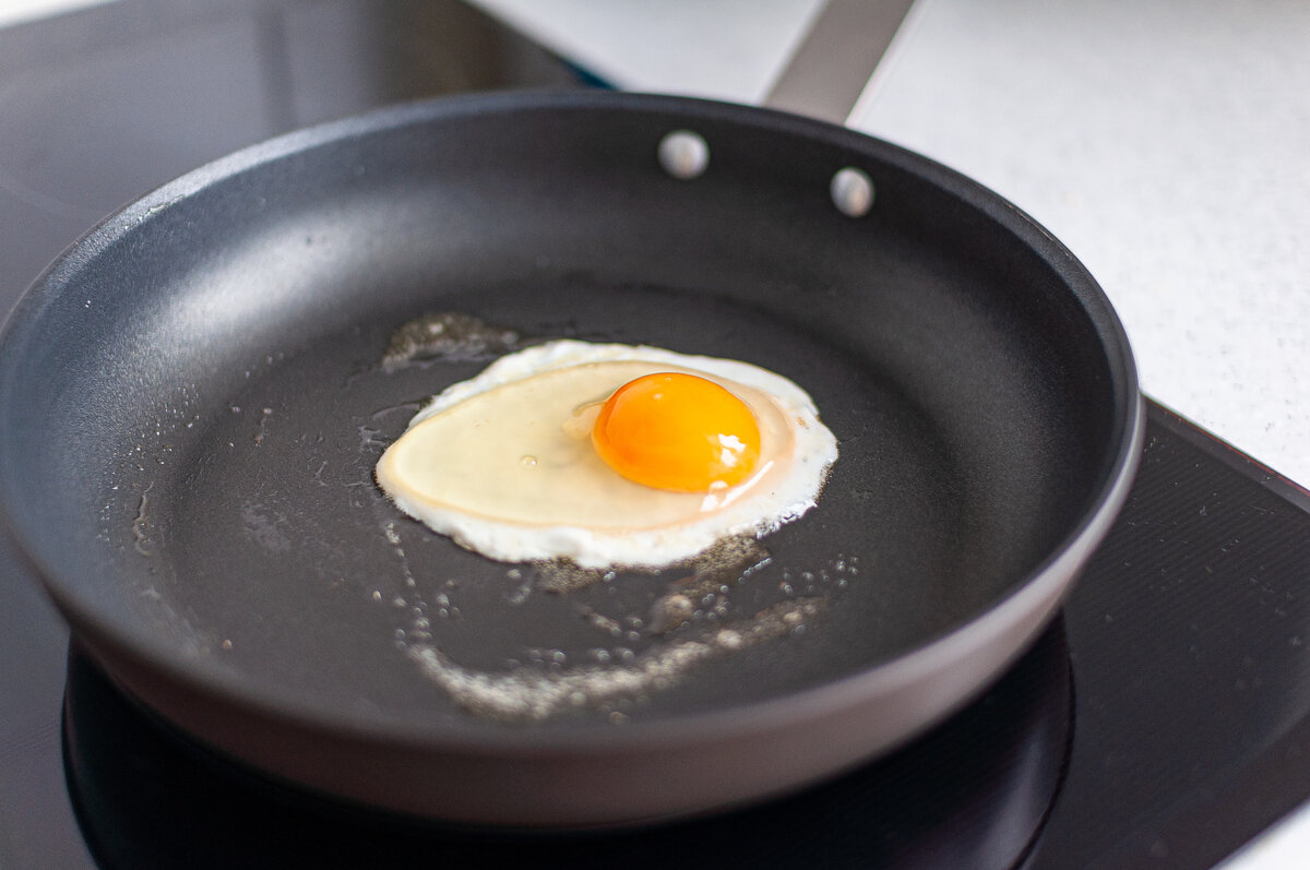 Яйцо на воде в сковороде. Сковорода с яичницей. Сковородка для яичницы. Сковорода для яиц. Жареные яйца на сковороде.