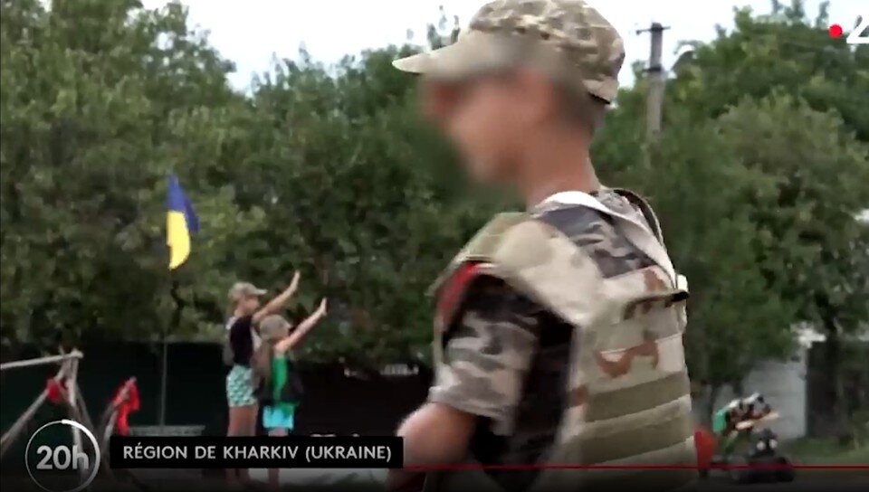 Cтоящие на заднем плане девочки также приветствовали украинских военных, но совсем на другой манер Кадр видео