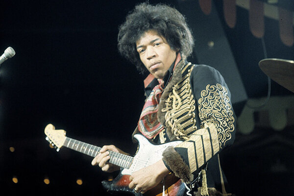 Джими Хендрикс выступает на концерте.