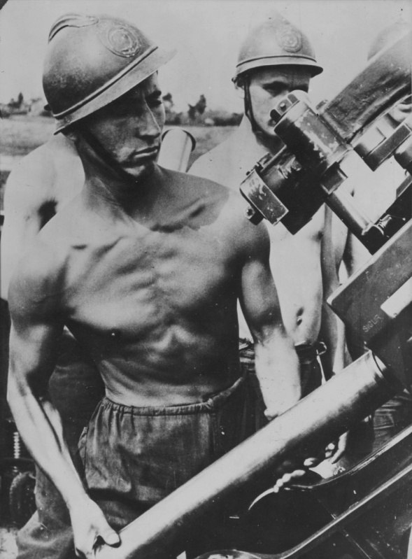 Заряжающий румынского зенитного расчета за работой
