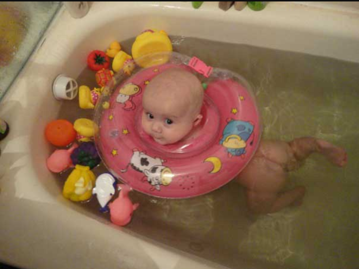 Купание ребенка с кругом на шее. Круг для малышей для купания в ванной. Купание малыша в ванной с кругом. Ванна для купания новорожденных в круге.