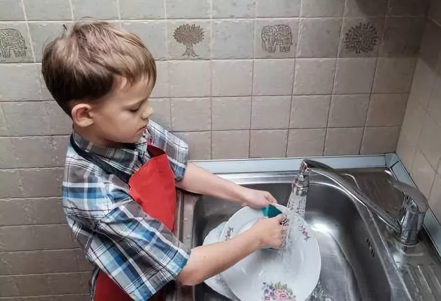 Мальчик моет тарелку. Пацан моющий посуду. Детская посуда мытье.