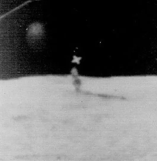 Структура ниже известна как «Осколок».  Он был запечатлен на фотографии, сделанной лунным орбитальным аппаратом LO-III в 1967 году, и находится недалеко от кратера Брюса. 
Если смотреть в профиль, можно увидеть, что удлиненный объект неправильной формы имеет высоту более мили. 
Анализ фотографии позволяет предположить, что объект состоит из материала с высокой отражающей способностью, почти стекловидного вещества. 
(Крест - добавленная фотографическая регистрационная метка).