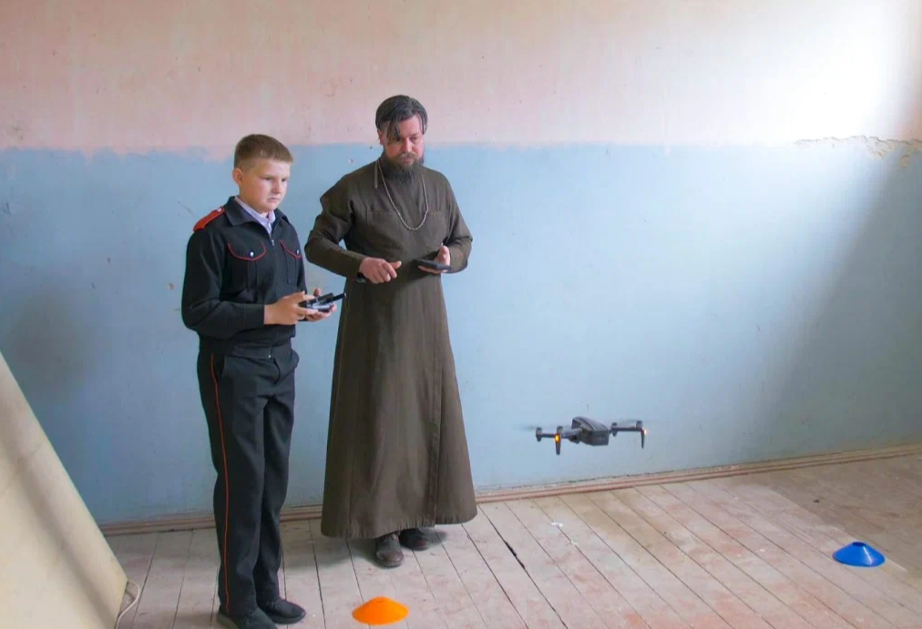 Священник Игорь Бирюков с учеником изучают возможности квадрокоптера