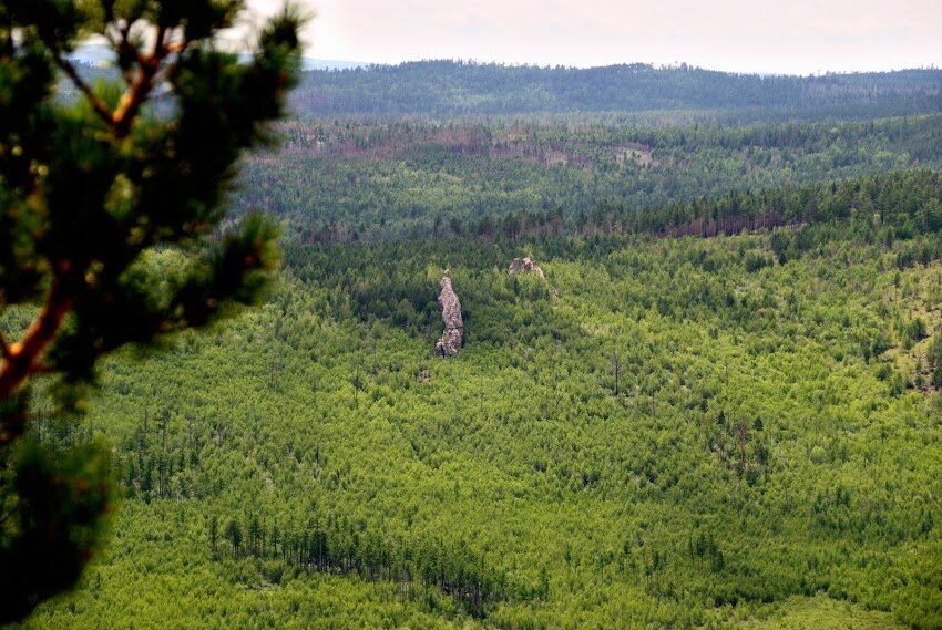 Вдалеке среди леса виден очень любопытный скальный выступ