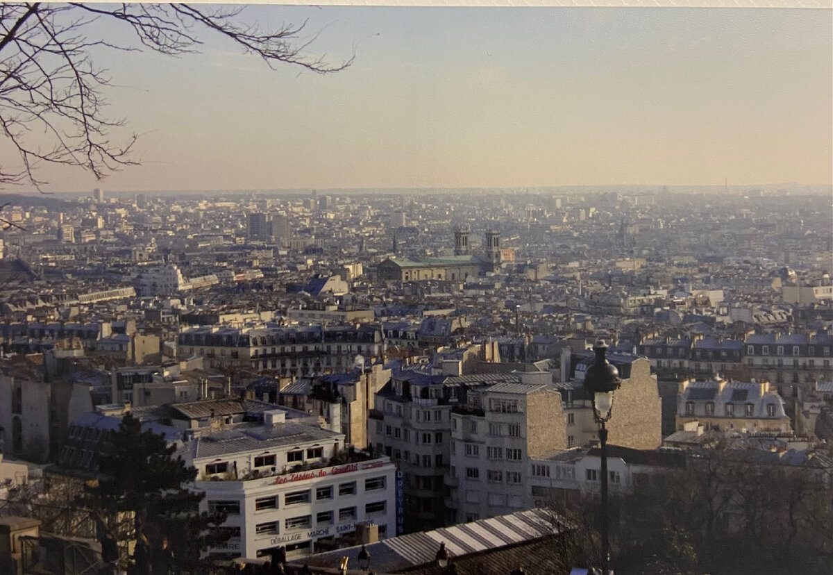 Фотография из личного архива. Мне очень нравится архитектура Парижа. Уютные мощеные брусчаткой улочки, дома с мансардами, кафе с теплыми уличными лампами, предоставляющими возможность посидеть на веранде не только летом.  