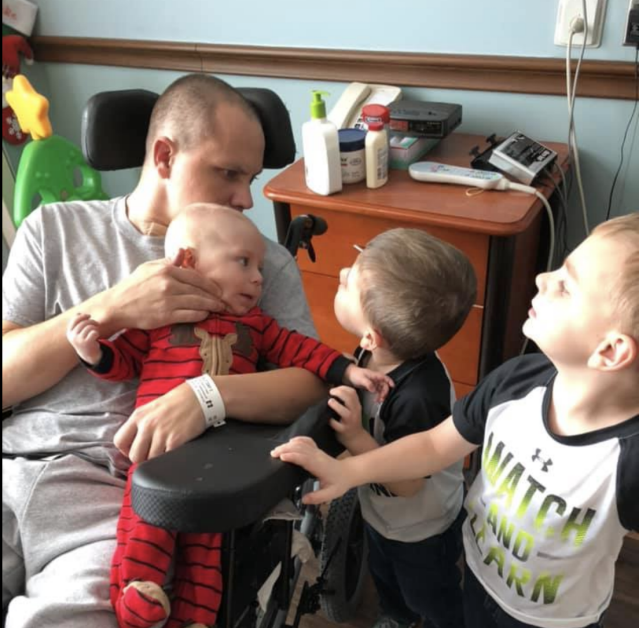 Тони Белт обнимает своих трех сыновей после выхода из комы.