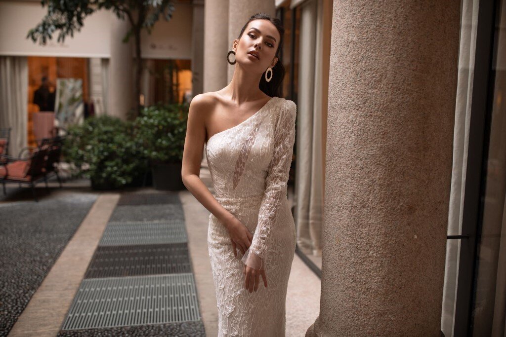 Невеста в свадебном платье силуэта «русалка» цвета айвори с асимметричным кроем верха