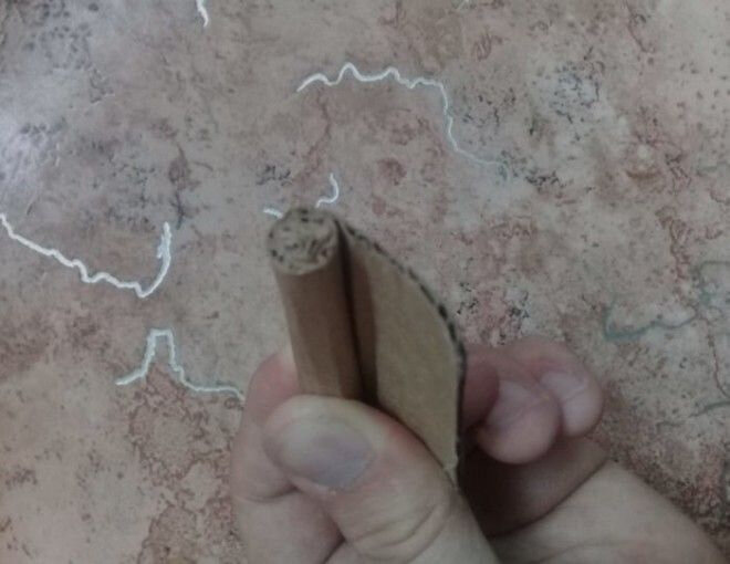 1.Разлинуйте лист картона, прямоугольник 5 на 10 см подойдёт идеально. Сворачивайте картон в «сигару» и фиксируйте нитками.