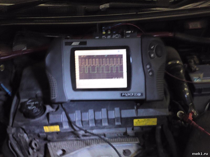 Осциллограф на двигателе, с осциллограмой на экране 