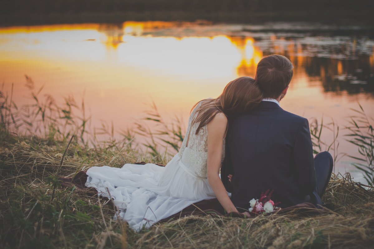 https://www.pexels.com/photo/wedding-couple-sitting-on-green-grass-in-front-of-body-of-water-at-sunset-70737/