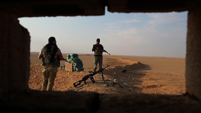 Члены Народных подразделений Ирака охраняют пограничный район с Сирией в Аль-Каиме  (Фото AFP)