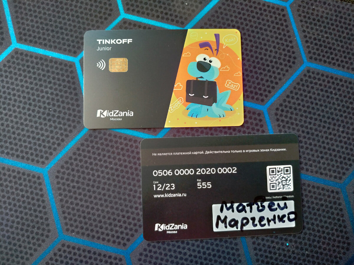 Карты снабжены настоящим чипом. Номера на них для виду, они на всех картах одинаковые. А вот qr-код — настоящий, по нему можно узнать баланс карты на сайте card.kidzania.ru (соответственно, нужна камера; на снимке код заменён). У меня не получилось через сайт прочитать карту, камера не поддерживалась (пробовал разные браузеры и разные смартфоны).