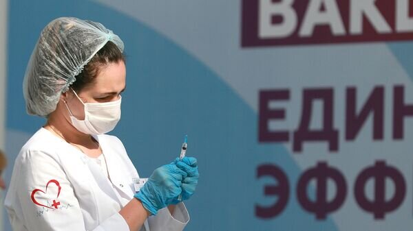    Медицинский работник держит в руках шприц с вакциной "Гам-Ковид-Вак" ("Спутник V") © РИА Новости / Антон Денисов