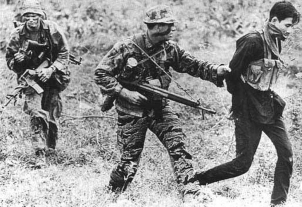 Боец морского спецназа США ("морской котик") ведёт пленного партизана. Вьетнам 1969 год