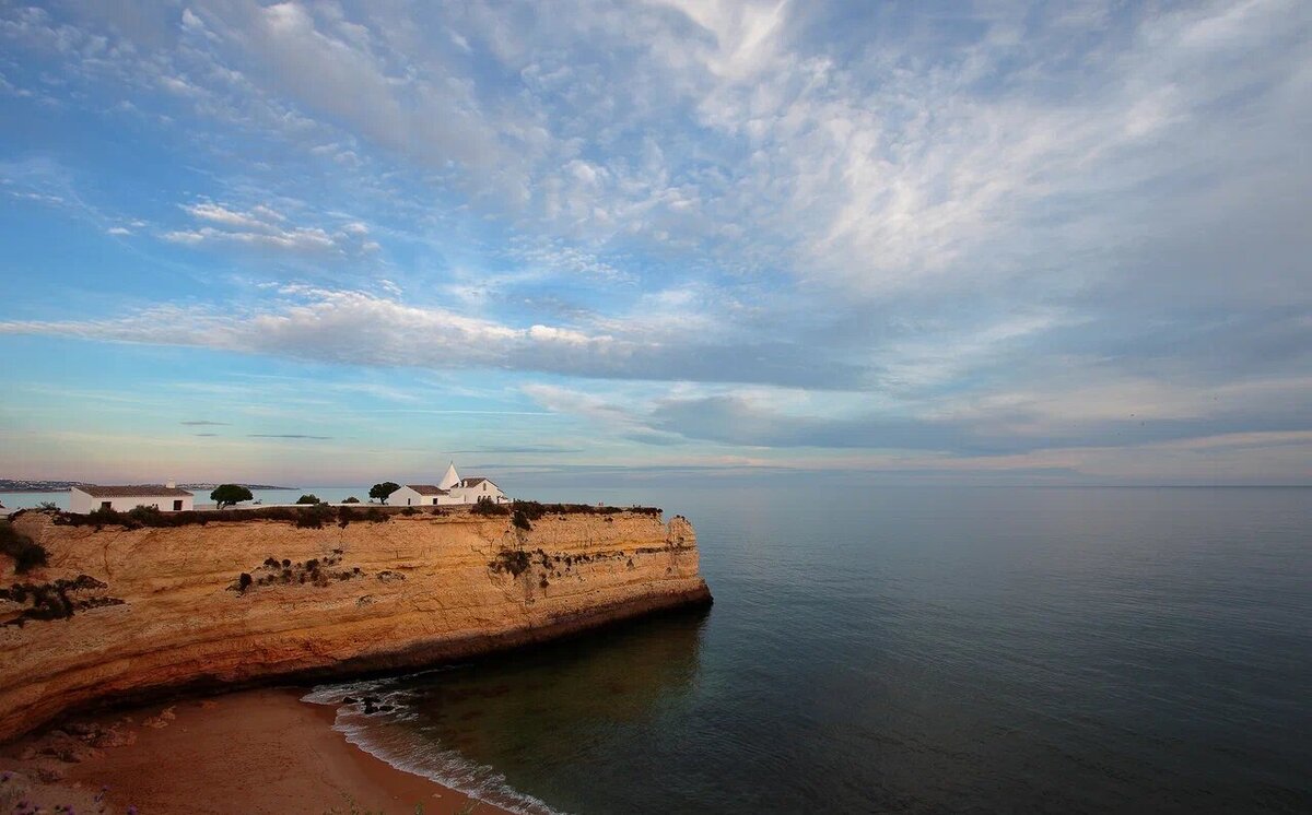 Характерная картина для пляжей Португалии – многие из них окружены известняковыми скалами. Фото: Dmitri Speaker, Flickr