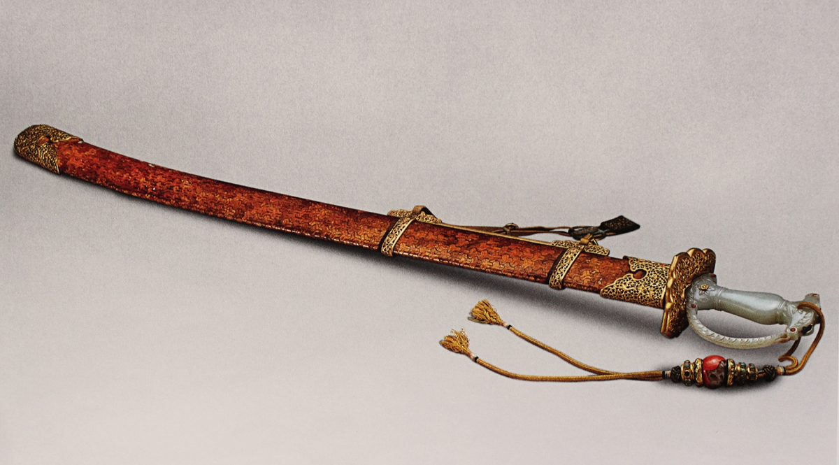 Поясная сабля номер 19 из “Небесной серии” императора Цянлуна сделанная по его величества высочайшему повелению. На лезвии выбито название сабли “Приводящая к порядку дезертиров", прямая рукоять из нефрита, ножны декорированы плетеным орнаментом из золотистой коры персикового дерева. Вес 932 грамма. Ящик номер 4. 