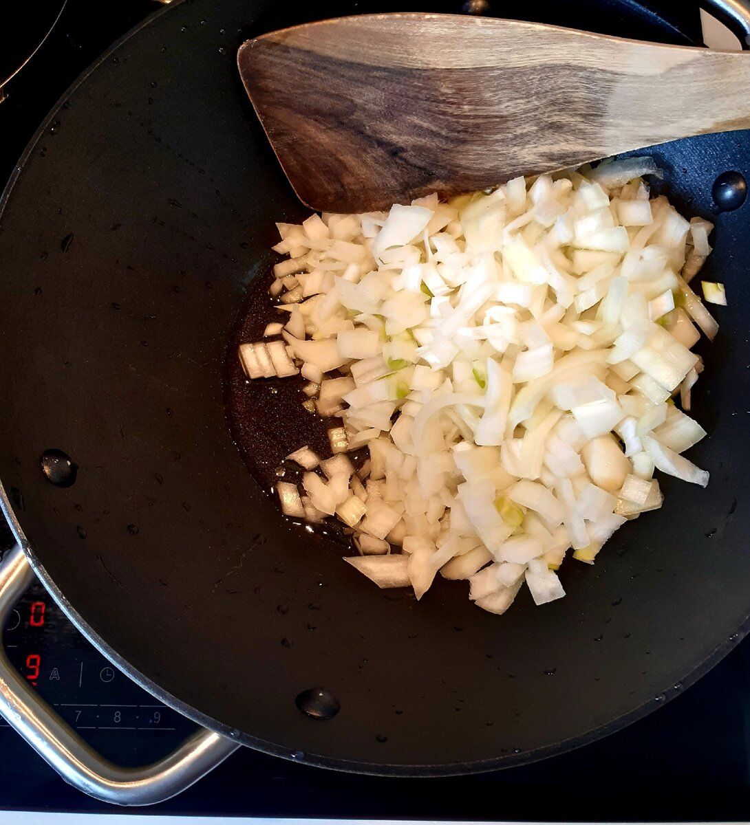 Оливковое масло раскаляем в казане или сковороде вок, добавяем лук и обжариваем до золотого цвета