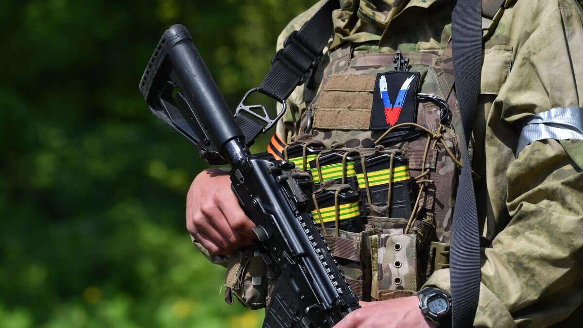    Нашивка со знаком "V" на форме военнослужащего разведгруппы ВС России, работающего на Харьковском направлении© РИА Новости / РИА Новости