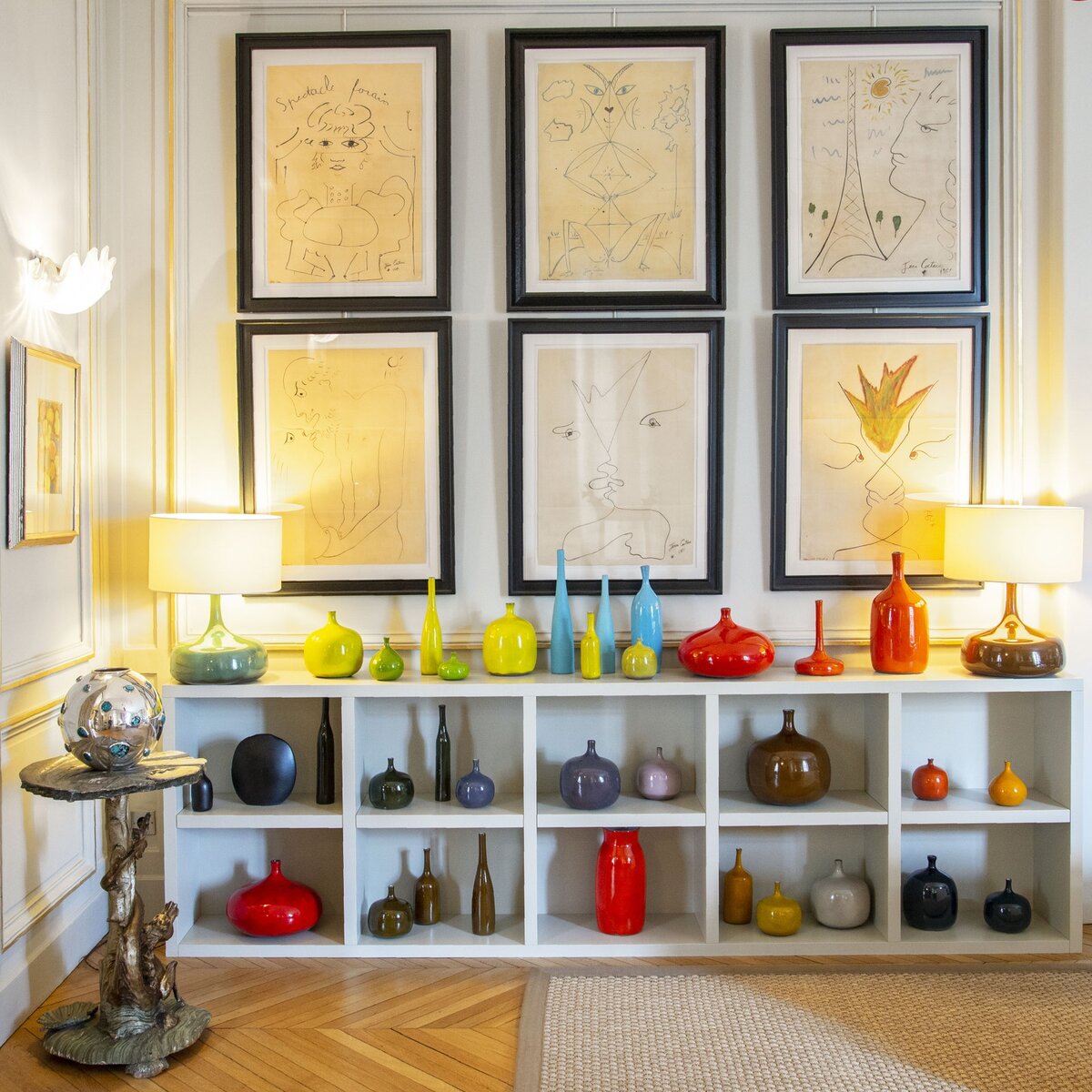 Коллекция Рапина с французской керамикой Ruelland 1960-х годов. На стене висят шесть рисунков Жана Кокто, также 1960-х годов. Маленькие австрийские столики из посеребренного дерева - конца 19-го века, вазы и камни - производства фирмы Kam Tim.