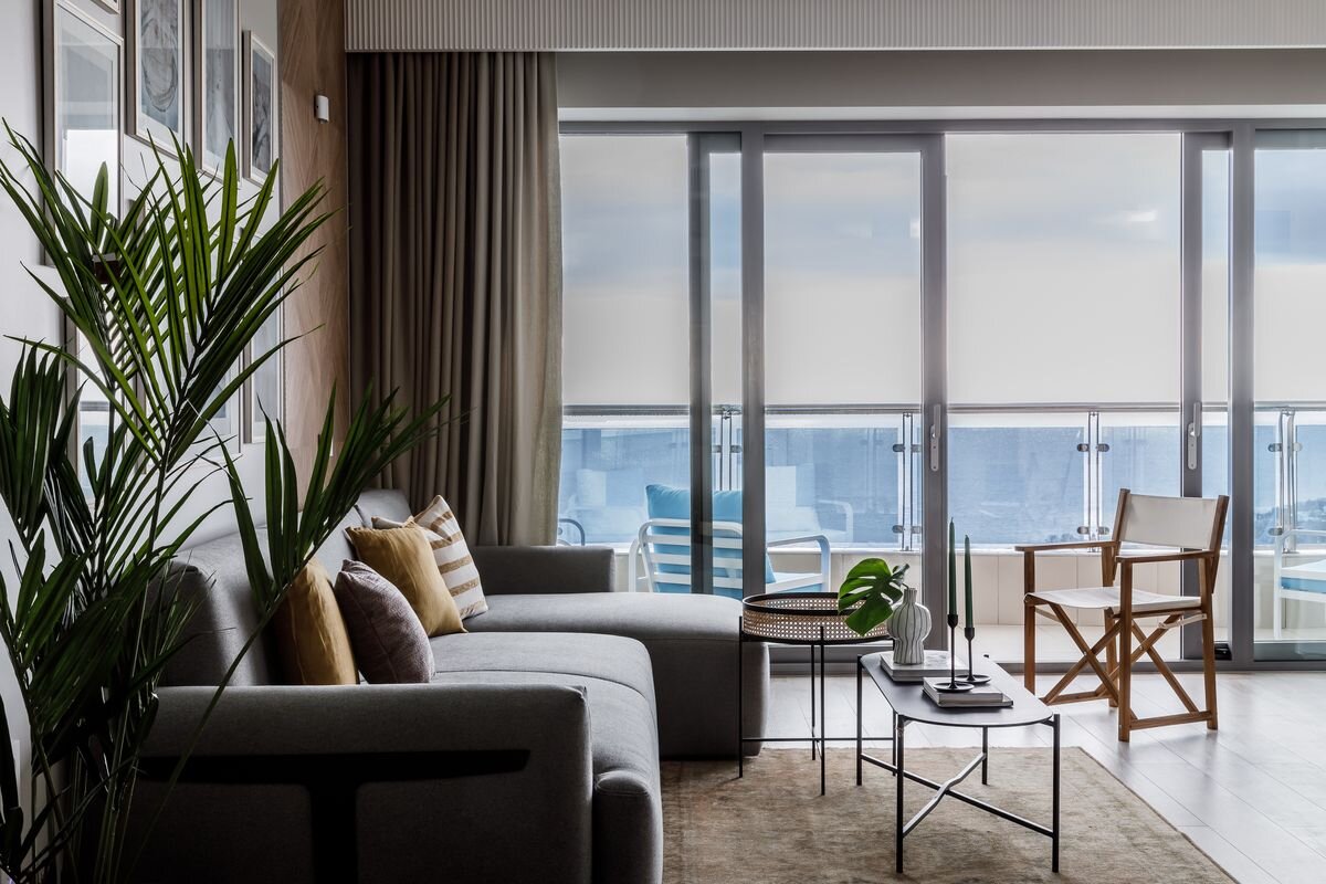 Большой мягкий диван дополнили аскетичным режиссёрским креслом. Фотокартины на стене создали на основе снимков, которые предоставила заказчица.