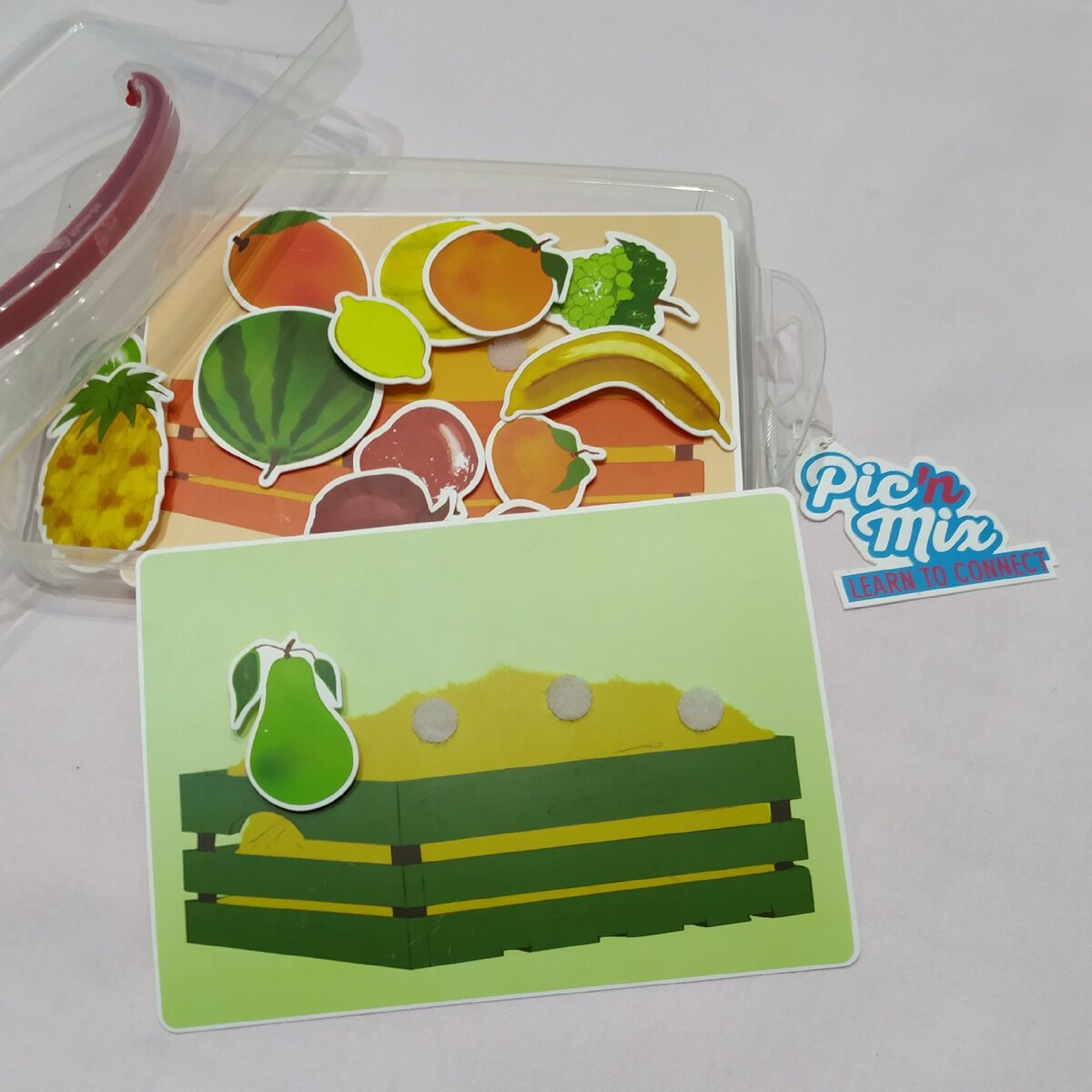 Игра с липцчками от Pic'n Mix:4 карточки с разноцветными ящиками - зелёный, жёлтый, красный, оранжевый.16 фруктов (за одно и фрукты подучить можно).Так же в комплекте есть 3 карточки с тарелками, где нарисованы фрукты в разрезе. Пластик плотный.Рекомендую)