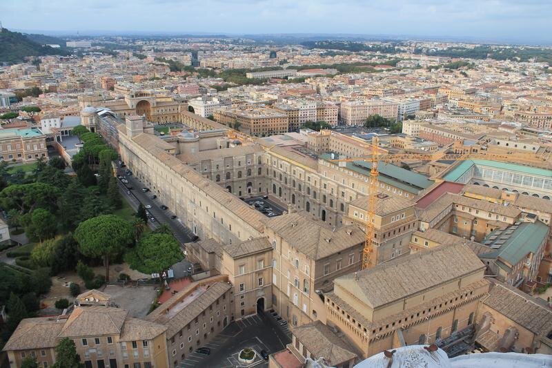 Сикстинская капелла, вид сверху. Понять среди этих однообразно-умилительных коричневых крыш, что есть что, не так-то просто. Капелла - в правом нижнем углу, там где подъёмный кран. Всё остальное сейчас называют «Музеи Ватикана». Сейчас там толпы туристов, а когда-то всё принадлежало одному-единственному папе. 