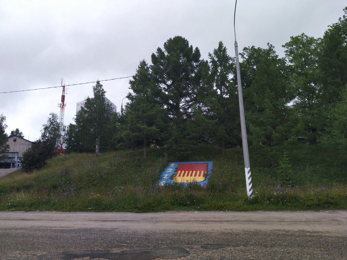 Зарастающая табличка с датой основания и гербом города, выходящая на Рижское шоссе. Чтобы все проезжающие знали!