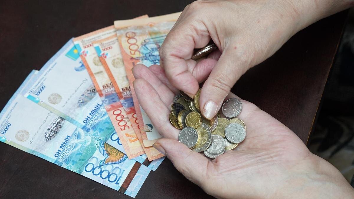    Женщина считает монеты тенге:NUR.KZ/Владимир Третьяков