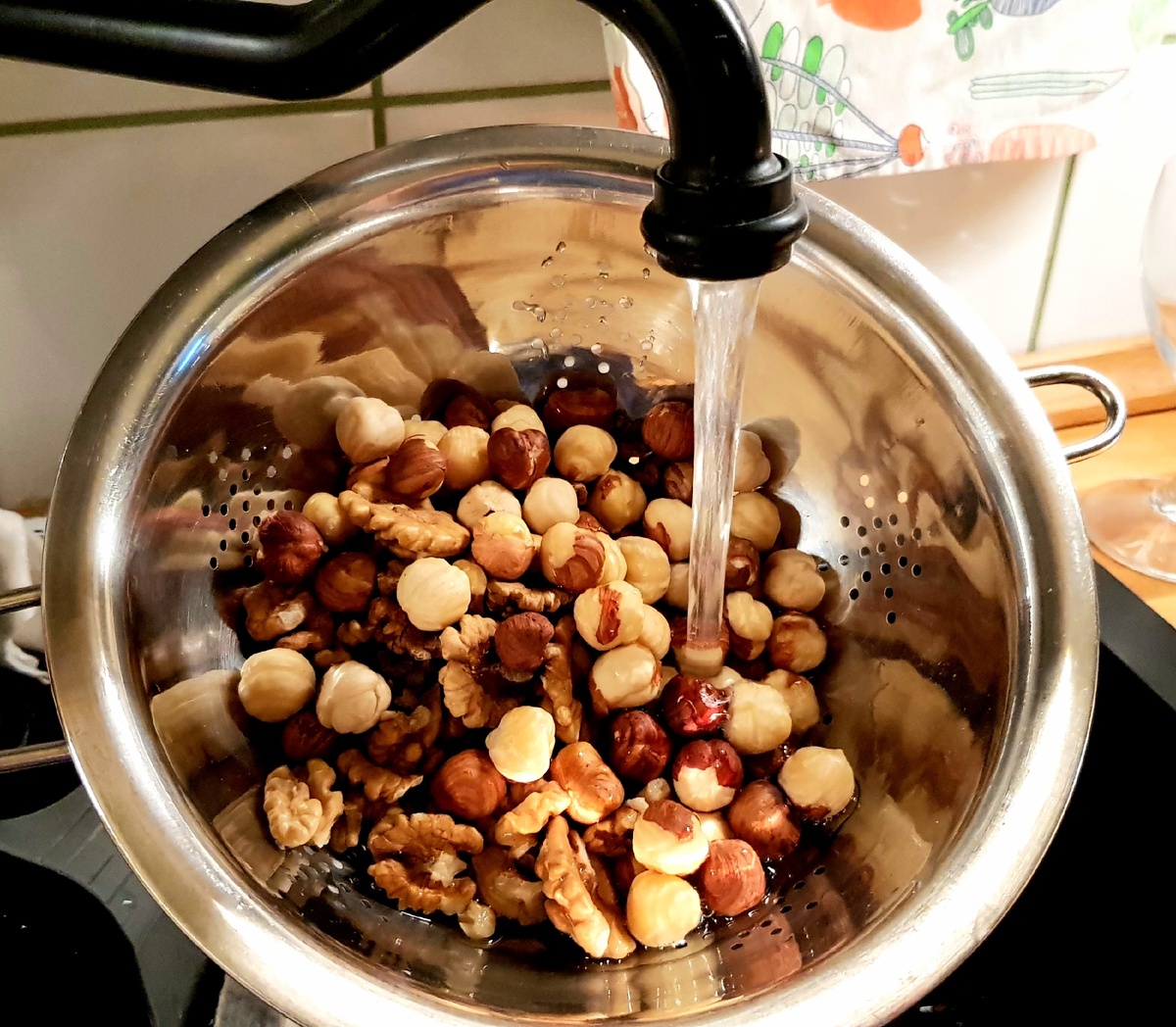 Выкладываем орехи в дуршлаг и промываем под проточной водой